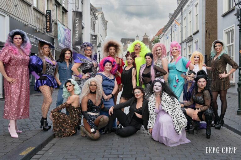 Een stralende groepsfoto van dragqueens en deelnemers als afsluiting van Drag Camp Amsterdam, vol glitter, glamour en onvergetelijke herinneringen